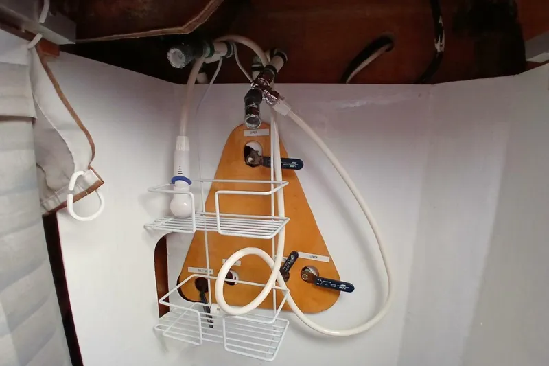 Slide: The Image of 1976 Islander Freeport boat interior with plumbing and storage shelves. - 21