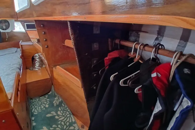 Slide: The Image of 1976 Islander Freeport yacht interior with wooden closet and hanging jackets. - 28