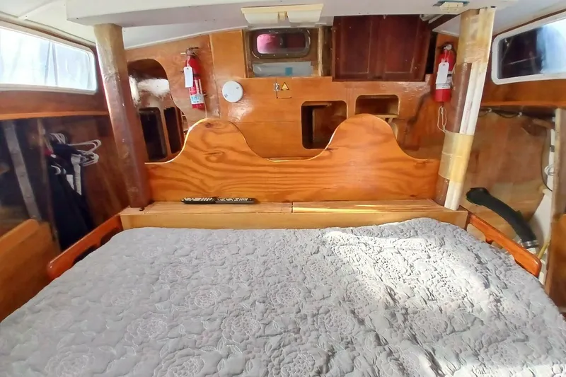 Slide: The Image of 1976 Islander Freeport cabin interior with wooden finish and cozy bedding. - 29