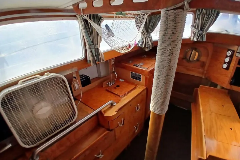 Slide: The Image of 1976 Islander Freeport yacht interior with wood finish, fan, and nautical decor. - 3