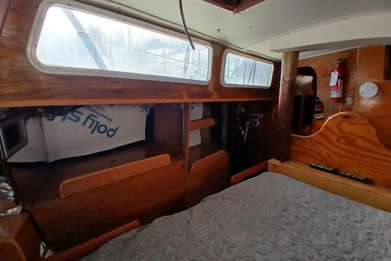 Slide: The Image of 1976 Islander Freeport cabin interior with wooden finish and cozy sleeping area. - 30