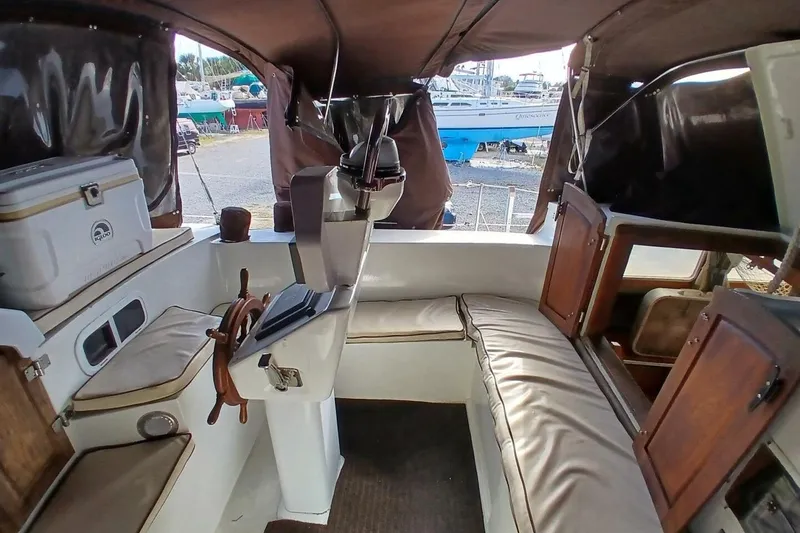Slide: The Image of 1976 Islander Freeport sailboat interior with seating, steering wheel, and storage compartments. - 35