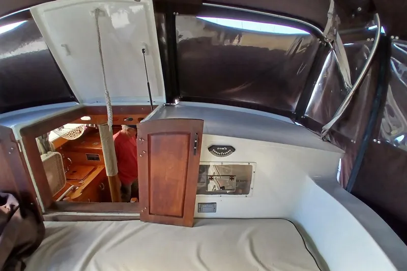 Slide: The Image of 1976 Islander Freeport sailboat interior with wooden cabinetry and cozy seating area. - 36