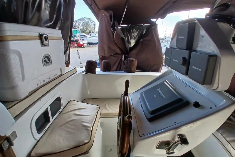Slide: The Image of 1976 Islander Freeport boat cockpit with steering wheel, navigation equipment, and seating. - 37