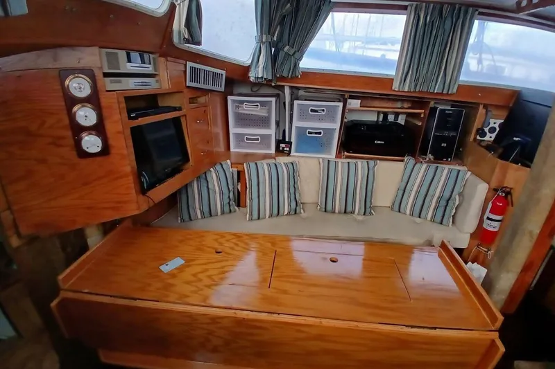 Slide: The Image of 1976 Islander Freeport yacht interior with wood finish, striped cushions, and storage compartments. - 4