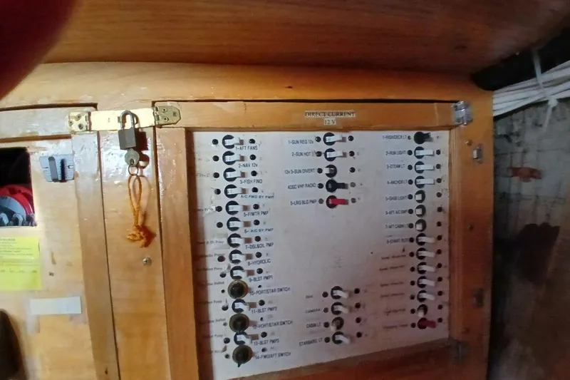 Slide: The Image of Electrical panel inside a 1976 Islander Freeport boat, featuring labeled switches and a wooden enclosure. - 40