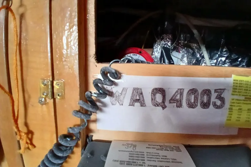 Slide: The Image of Interior of 1976 Islander Freeport boat with coiled cable and handwritten label "WA Q4003". - 43