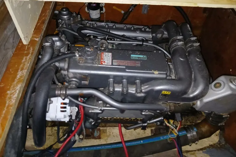 Slide: The Image of Engine compartment of a 1976 Islander Freeport sailboat, showcasing mechanical components and wiring. - 46