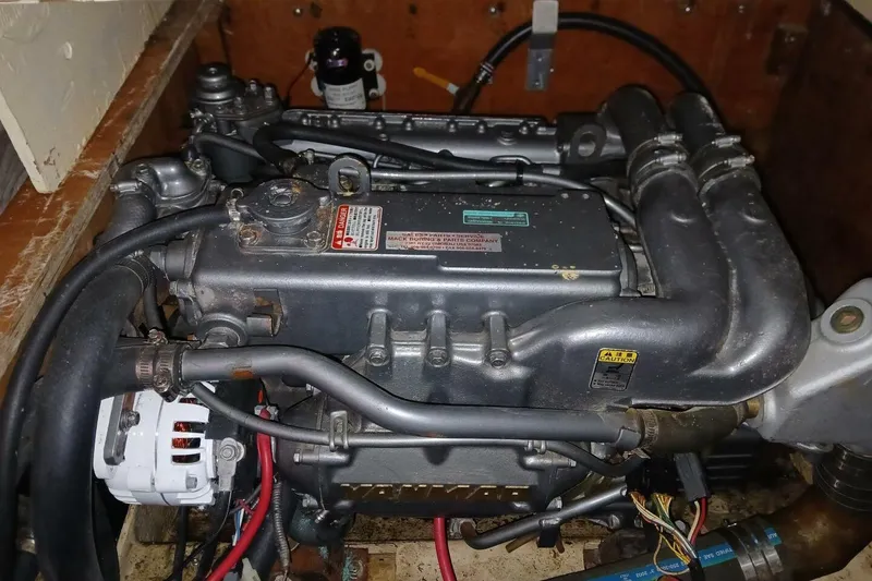 Slide: The Image of 1976 Islander Freeport engine with visible components and wiring in a wooden compartment. - 47