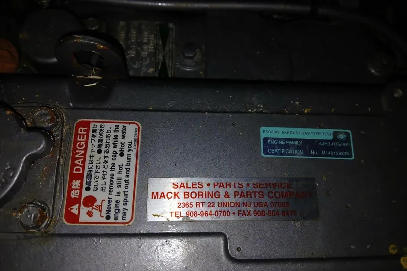 Slide: The Image of Engine compartment of a 1976 Islander Freeport with warning and service labels visible. - 50