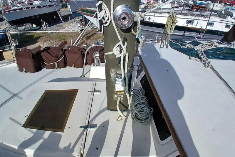 Slide: The Image of 1976 Islander Freeport sailboat deck with ropes and winch in a marina setting. - 52