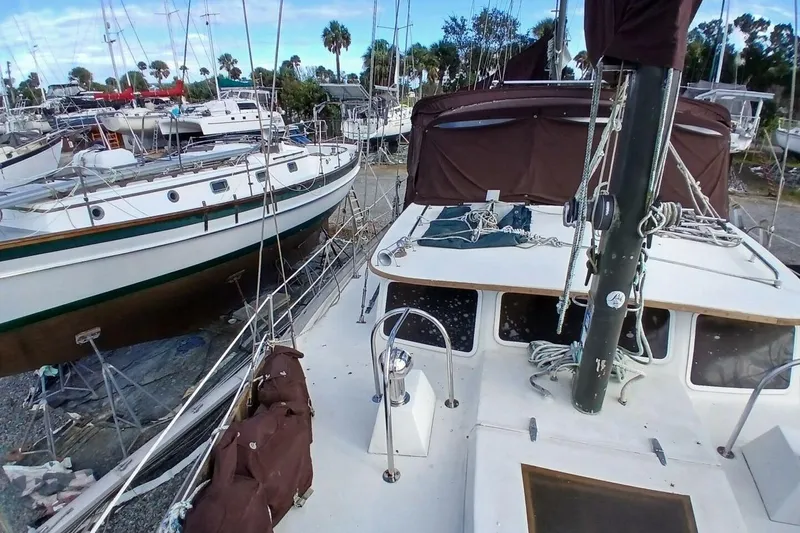 Slide: The Image of 1976 Islander Freeport sailboat docked among other vessels in a marina setting. - 54