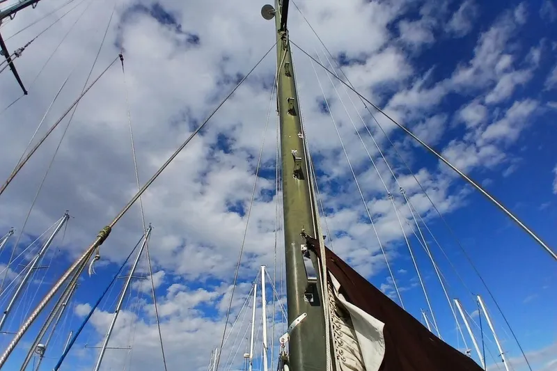Slide: The Image of 1976 Islander Freeport sailboat mast against a cloudy blue sky. - 58