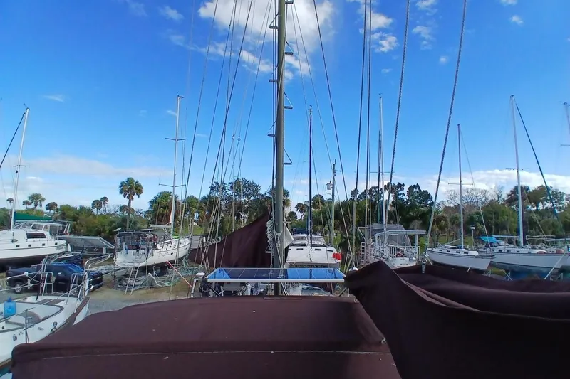 Slide: The Image of 1976 Islander Freeport sailboats docked under a clear blue sky. - 59