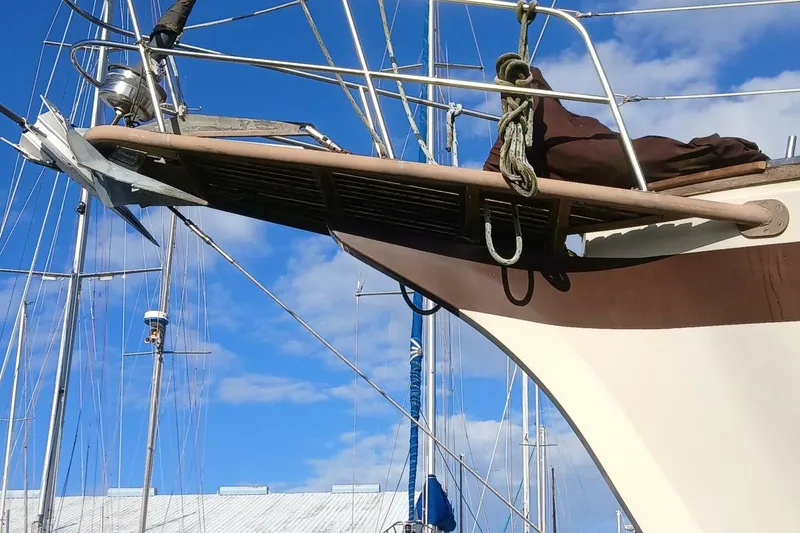 Slide: The Image of 1976 Islander Freeport sailboat bow with anchor, under clear blue sky. - 61