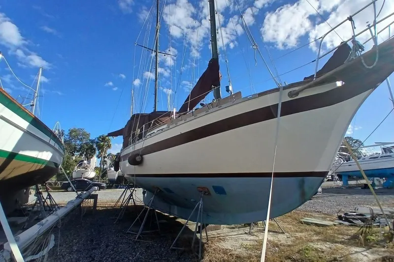 Slide: The Image of 1976 Islander Freeport sailboat on stands under a clear blue sky. - 63