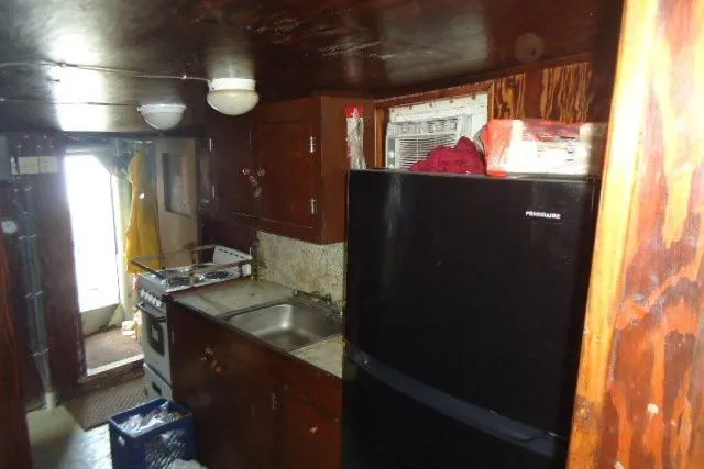 Slide: The Image of 1973 Commercial Boats Shrimp Trawler kitchen interior with wooden cabinets and appliances. - 8