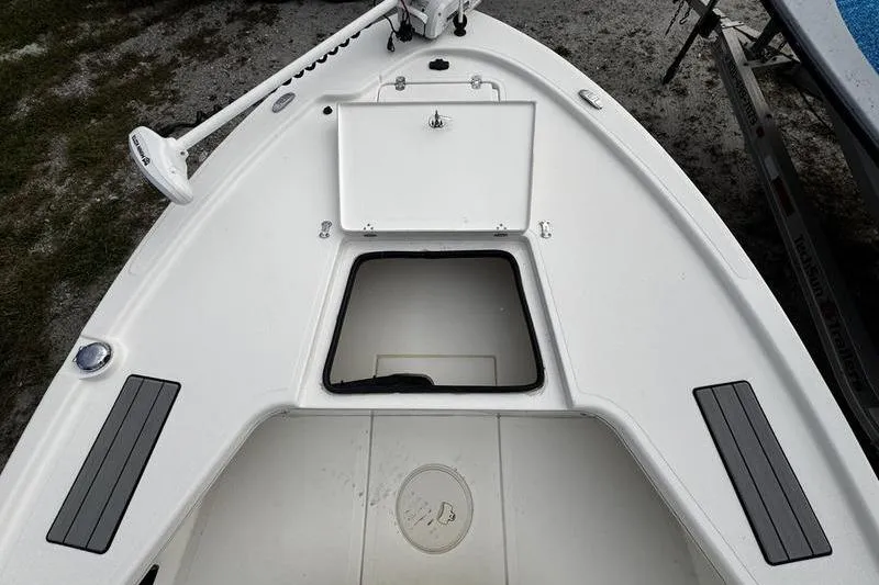 Slide: The Image of 2022 Mako 18 LTS boat deck with open storage compartment and trolling motor. - 10