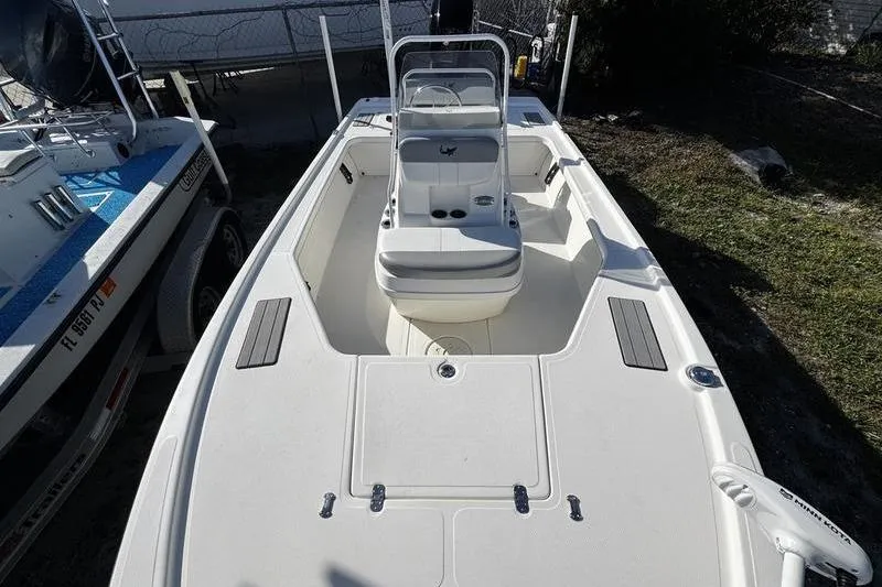 Slide: The Image of 2022 Mako 18 LTS boat with center console and seating, docked outdoors. - 11