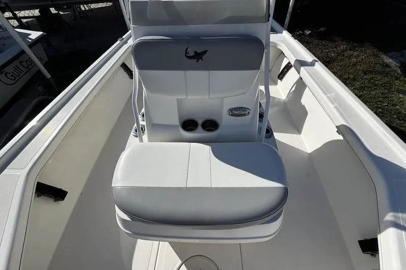 Slide: The Image of 2022 Mako 18 LTS boat interior with cushioned seating and cup holders. - 14