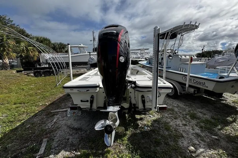 Slide: The Image of 2022 Mako 18 LTS boat with outboard motor, parked on grassy area under cloudy sky. - 3