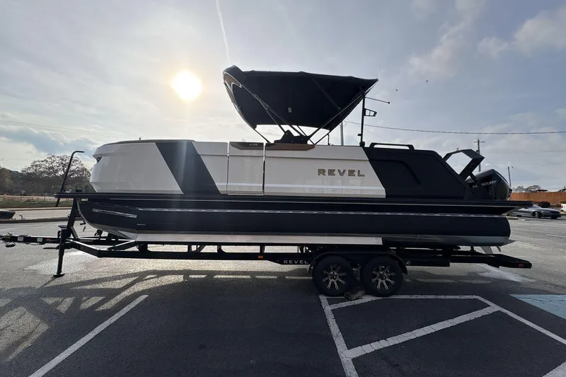 Slide: The Image of 2026 Revel RS25 boat on trailer, parked outdoors near a building. - 2