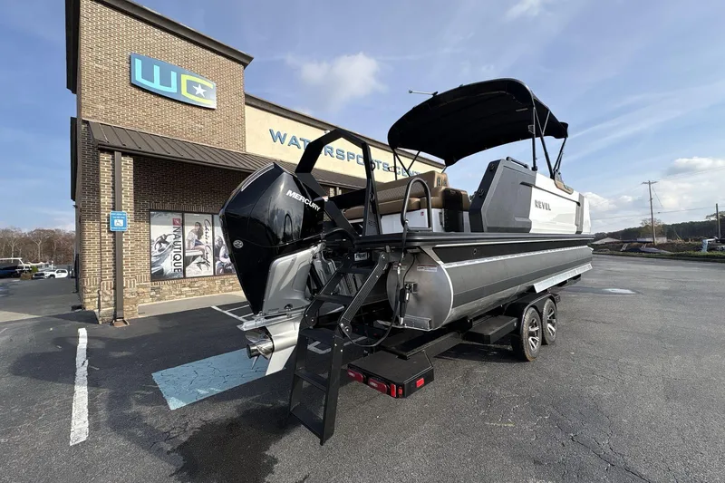 Slide: The Image of 2026 Revel RS25 boat on trailer outside a watersports store. - 4