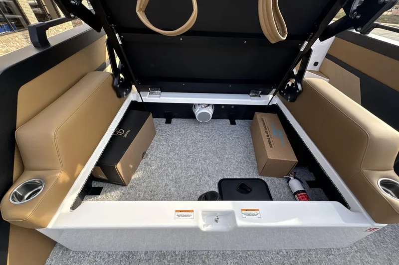 Slide: The Image of Open storage compartment in 2026 Revel RS25 boat with beige seating and accessories. - 7