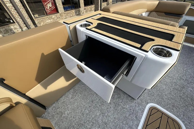 Slide: The Image of Revel RS25 2026 boat interior with open storage drawer and cup holders. - 9