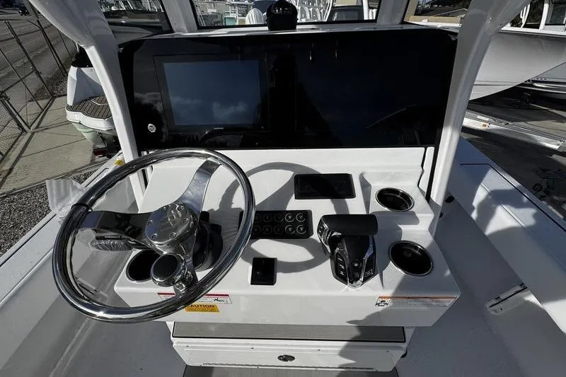 Slide: The Image of 2026 Sportsman Masters 247 Bay Boat helm with steering wheel and control panel. - 21