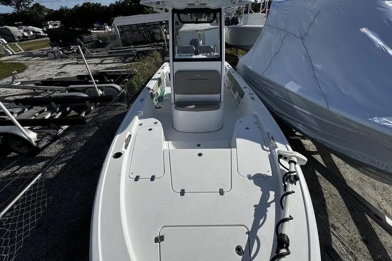 Slide: The Image of 2025 Sportsman Masters 227 Bay Boat with open storage compartments and visible equipment. - 8