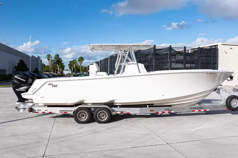 Slide: The Image of 2021 SeaVee 322Z boat on trailer, parked outdoors under blue sky. - 10