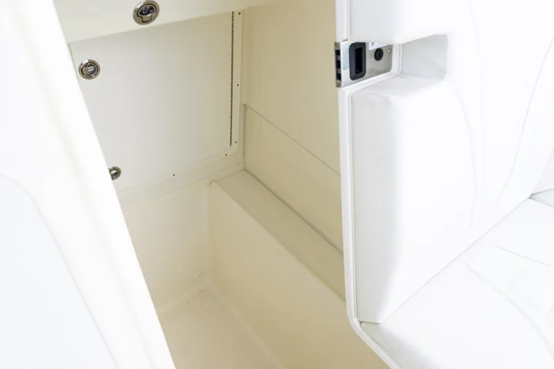 Slide: The Image of 2021 SeaVee 322Z boat interior storage compartment with white cushioned seating. - 23