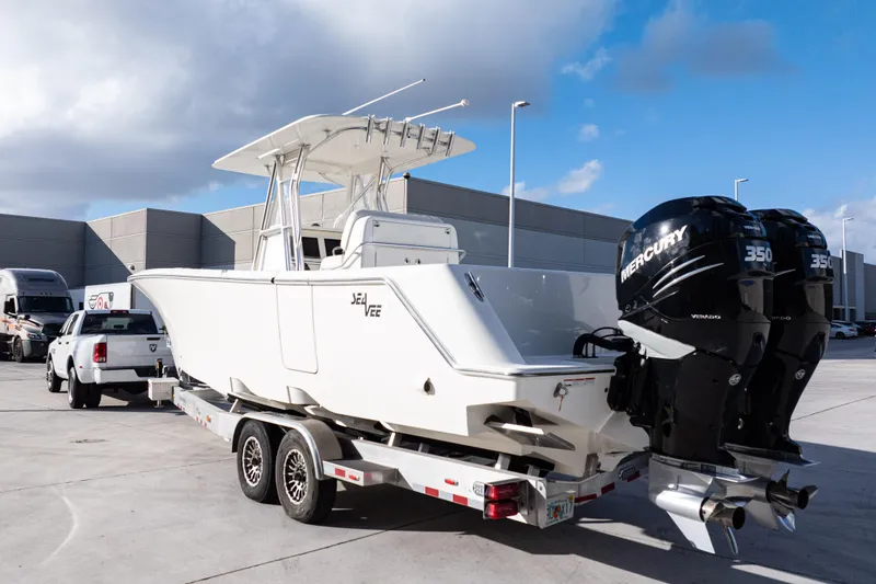 Slide: The Image of 2021 SeaVee 322Z boat on trailer with dual Mercury 350 engines, parked outdoors. - 4