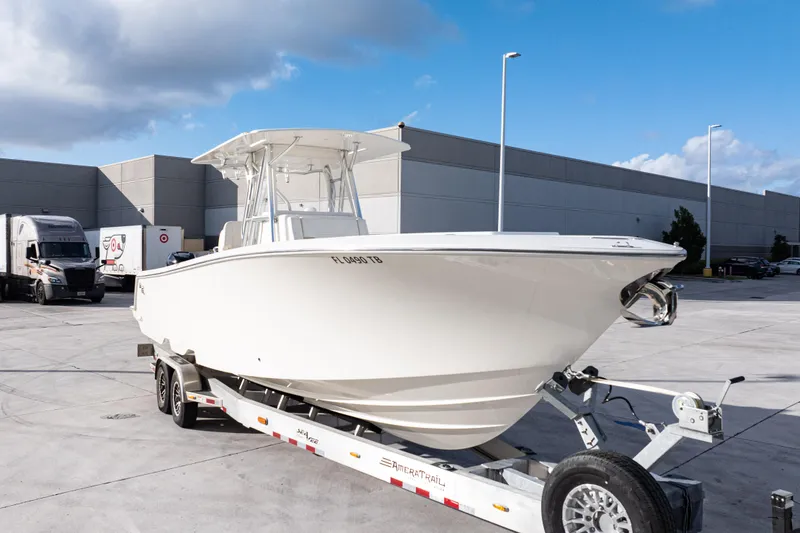 Slide: The Image of 2021 SeaVee 322Z boat on trailer in industrial parking lot under blue sky. - 7