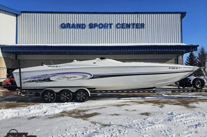 The Image of 2001 Baja 36 Outlaw boat on trailer at Grand Sport Center in snowy setting. - 1