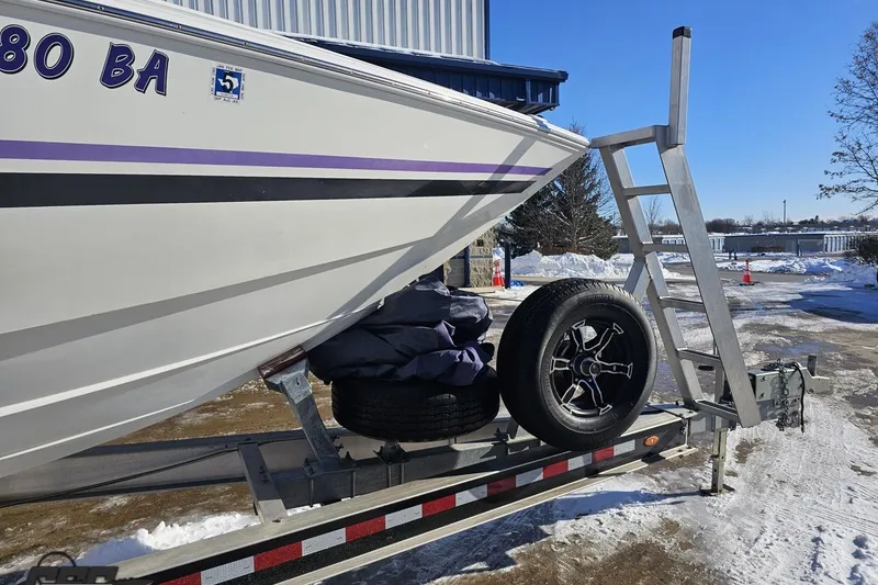 Slide: The Image of 2001 Baja 36 Outlaw boat on trailer, snowy background, spare tire visible. - 11