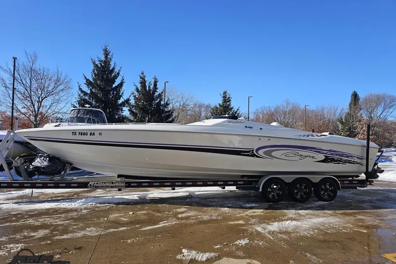 Slide: The Image of 2001 Baja 36 Outlaw speedboat on trailer, parked on snowy pavement under clear blue sky. - 19