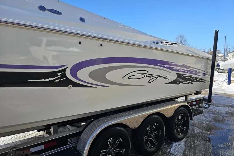Slide: The Image of 2001 Baja 36 Outlaw boat with purple graphics on a trailer. - 21