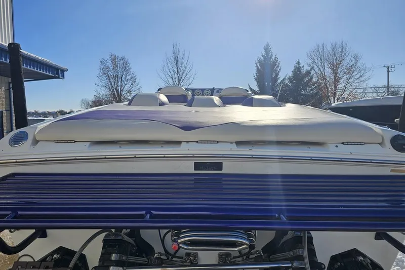 Slide: The Image of 2001 Baja 36 Outlaw boat, rear view, with blue and white detailing under clear sky. - 29