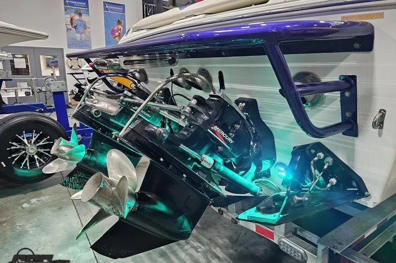 Slide: The Image of 2001 Baja 36 Outlaw boat with Mercury engine and dual propellers in a workshop. - 32