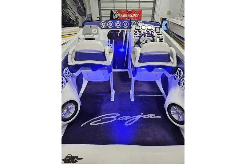 Slide: The Image of Interior of a 2001 Baja 36 Outlaw boat with illuminated dashboard and seating. - 41