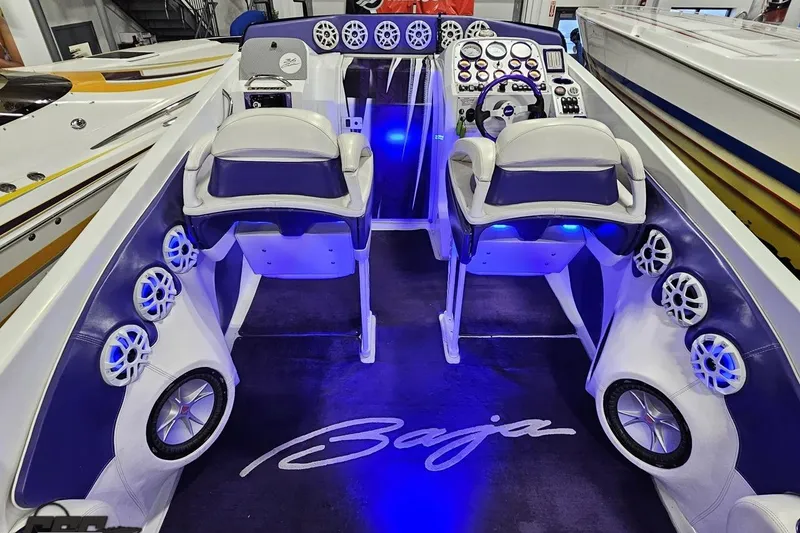 Slide: The Image of 2001 Baja 36 Outlaw boat interior with illuminated dashboard and seating. - 42