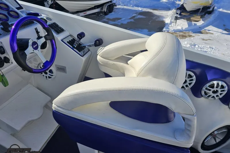 Slide: The Image of 2001 Baja 36 Outlaw boat cockpit with white and blue seating, steering wheel, and controls. - 48