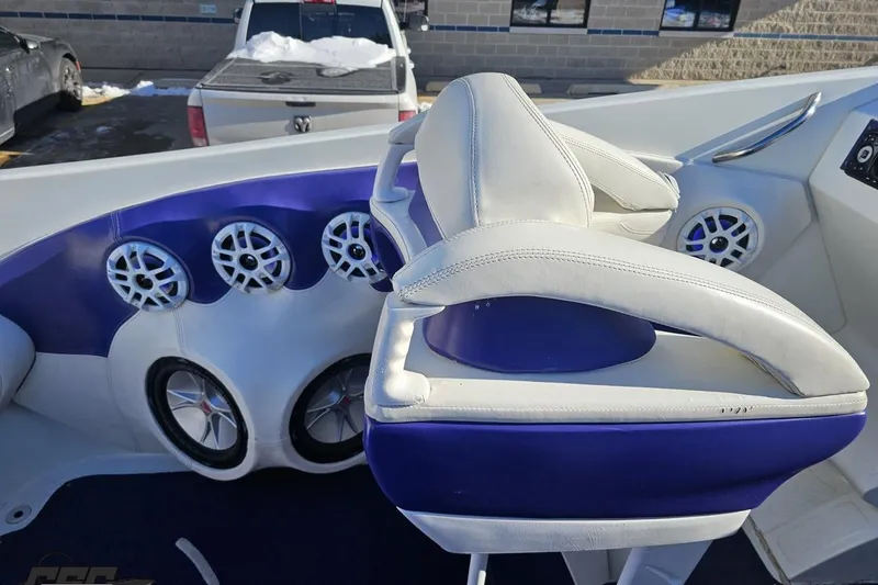 Slide: The Image of 2001 Baja 36 Outlaw boat interior with white and blue seating, featuring multiple speakers. - 49