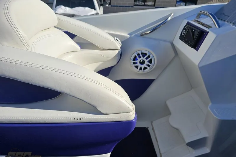 Slide: The Image of 2001 Baja 36 Outlaw boat interior with white and blue seating, speaker, and control panel. - 50