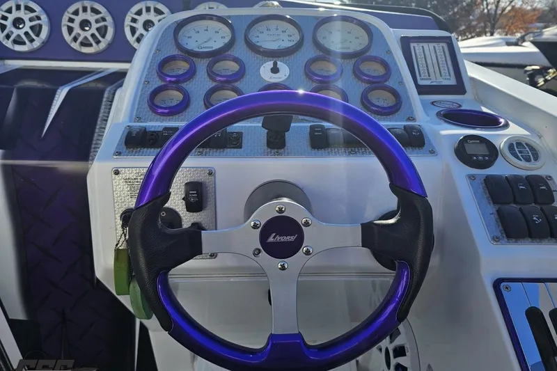 Slide: The Image of 2001 Baja 36 Outlaw boat dashboard with purple steering wheel and gauges. - 55
