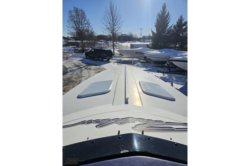 Slide: The Image of 2001 Baja 36 Outlaw boat in snowy outdoor storage, surrounded by trees and vehicles. - 60