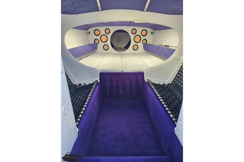 Slide: The Image of Interior of a 2001 Baja 36 Outlaw boat with purple and white upholstery. - 63