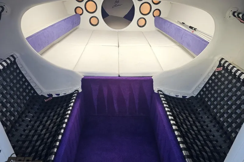 Slide: The Image of Interior of a 2001 Baja 36 Outlaw boat with purple and white seating. - 64